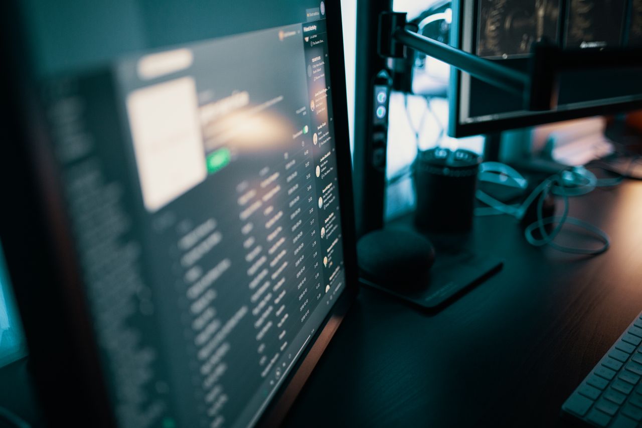 Home Sleek workspace featuring dual monitors in a dimly lit room, ideal for productivity and tech enthusiasts.