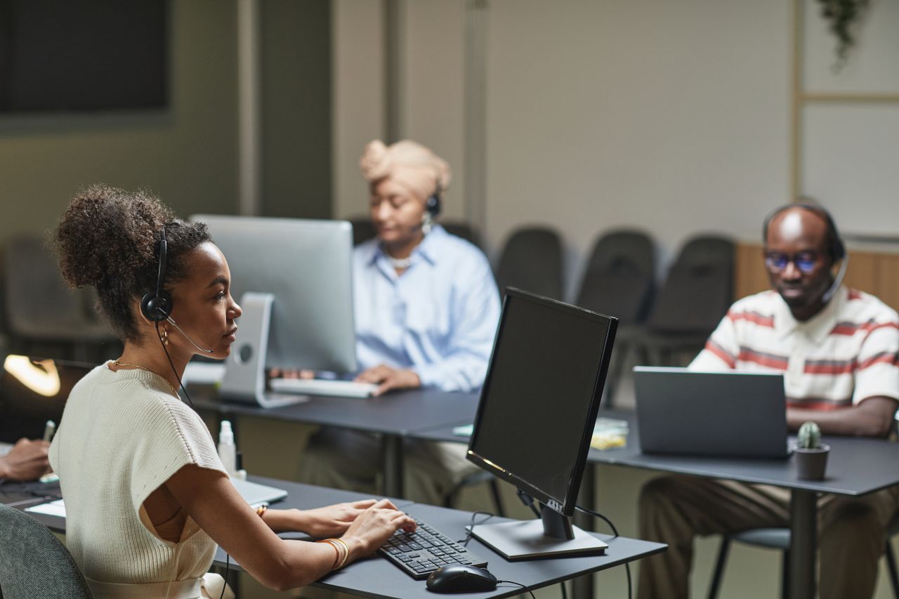 Home Three call center agents at work, focused and professional in a modern office environment.